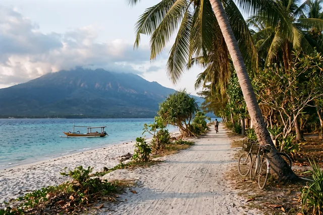 A sandy beach lane with bicycles on Gili Air, Mount Rinjani on Lombok across the water