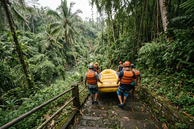 Rafters in helmets carrying an inflatable raft down the stone steps into the Ayung River gorge near Ubud